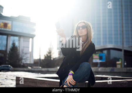 Young woman puckering lips while taking selfie in city Stock Photo