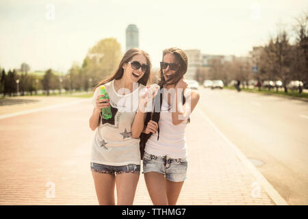 Cheerful female friends walking on street Stock Photo