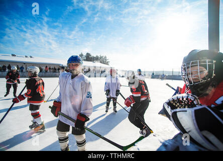 Players playing ice hockey on sunny day Stock Photo