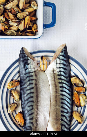 Overhead view of mackerels with oysters in dish on table Stock Photo