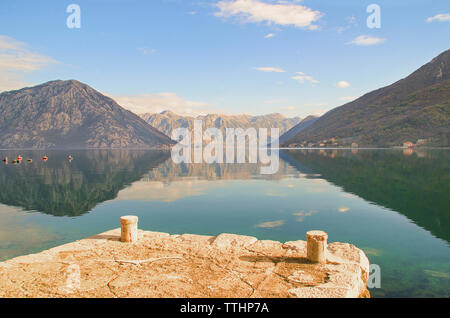 Kotor Bay with dramatic mountain reflections and Perast and Lovcen Mountain in the background Stock Photo