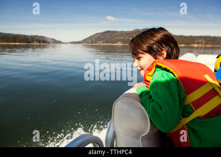 Boy looking at view while sitting on yacht Stock Photo