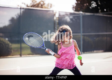 Girl playing tennis on court Stock Photo