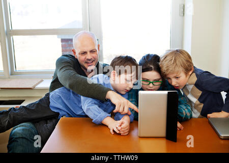 Family using tablet computer at home Stock Photo