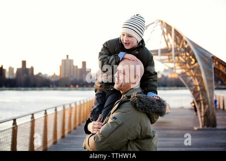 Side view of father carrying son Stock Photo