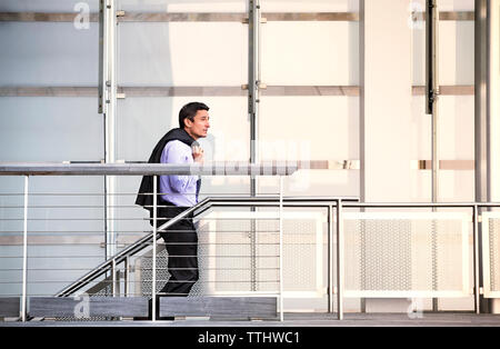 Side view of businessman standing on escalator Stock Photo