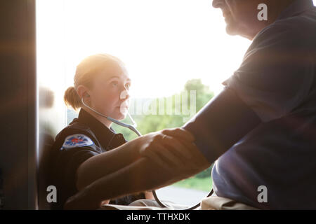 Close-up of paramedic checking man's blood pressure in ambulance Stock Photo