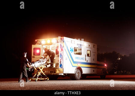 Paramedics lifting patient into ambulance Stock Photo - Alamy