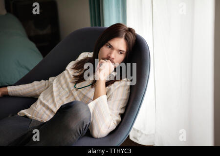 High angle view of thoughtful man sitting on chair at home Stock Photo