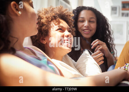 Happy siblings sitting on sofa at home Stock Photo