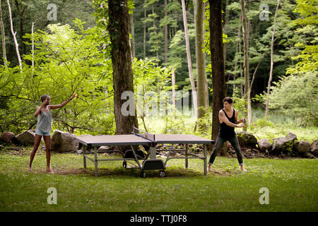 Couple playing table tennis in forest Stock Photo