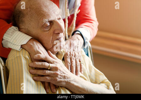 Midsection of woman with hands on senior man's shoulder Stock Photo
