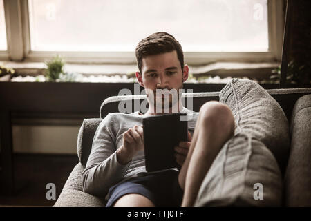 Man using tablet computer at home Stock Photo