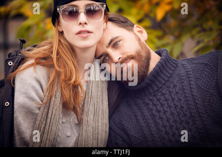 Man leaning head on woman's shoulder at park Stock Photo
