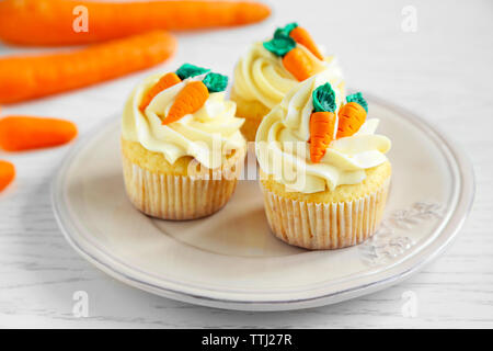 Plate with Easter cupcakes on wooden table Stock Photo