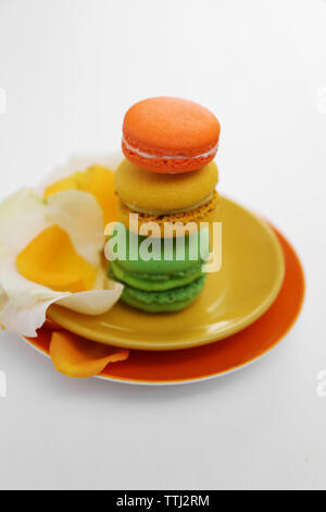 Plate with colorful macaroons on white background Stock Photo
