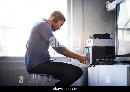 Side view of man listening music at home Stock Photo