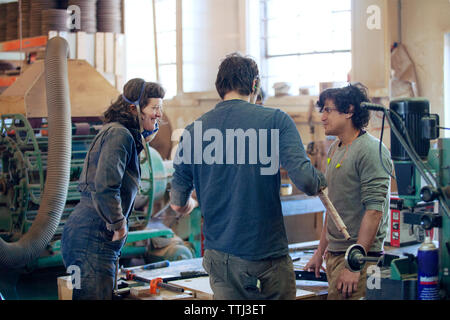 Carpenters discussing in workshop Stock Photo