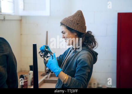 Side view of happy female carpenter in workshop Stock Photo