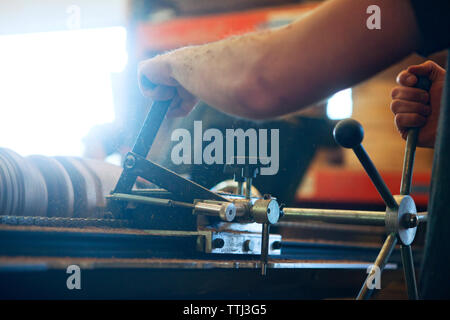 Cropped image of carpenter using machinery for carving wood in workshop Stock Photo