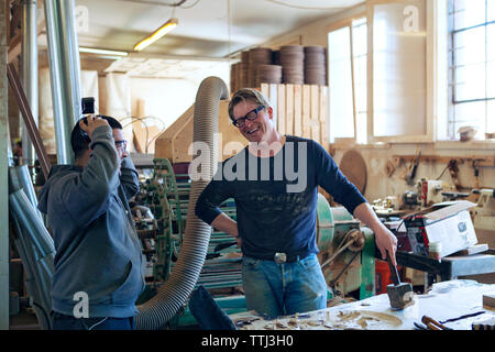 Happy male carpenters talking in workshop Stock Photo