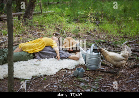 Family relaxing on blanket in forest Stock Photo