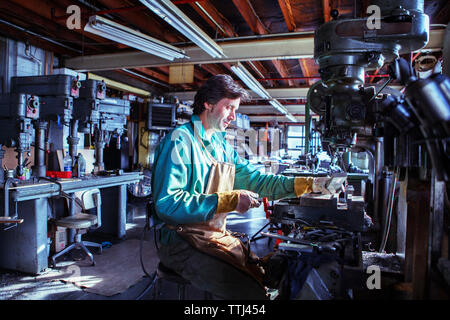 worker operating machine in workshop Stock Photo