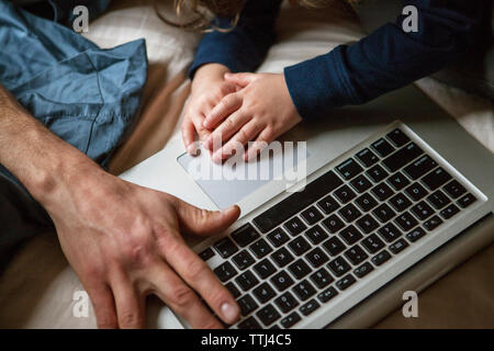 Cropped image of father and son using laptop computer Stock Photo