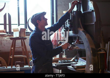 Carpenter using machinery in workshop Stock Photo