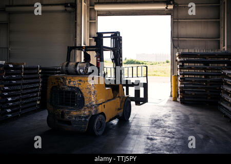 Rear view of worker driving forklift in metal industry while working Stock Photo
