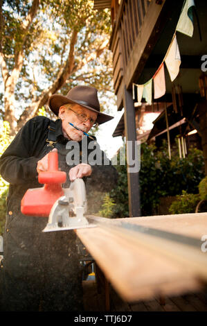 Carpenter using circular saw at workshop Stock Photo