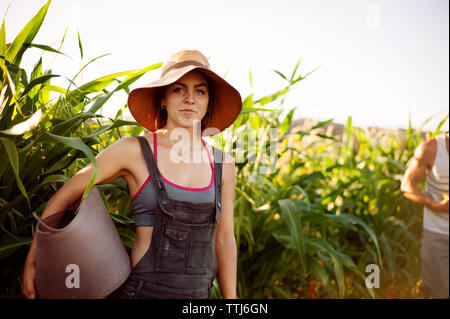 Portrait of woman carrying basket while standing in farm Stock Photo