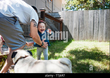 Happy family with dog playing in backyard Stock Photo
