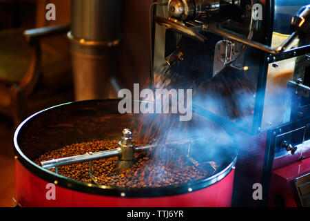 Coffee beans flowing from coffee roaster Stock Photo