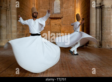 Group of Dervishes performing the traditional and religious whirling dance or Sufi whirling Stock Photo