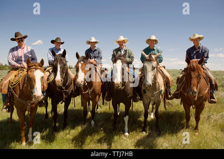 Portrait of cowboys sitting on horse against sky Stock Photo