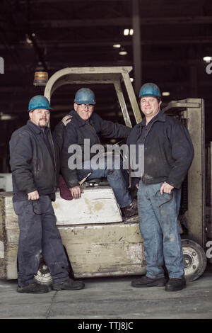 Portrait of workers with forklift in warehouse Stock Photo