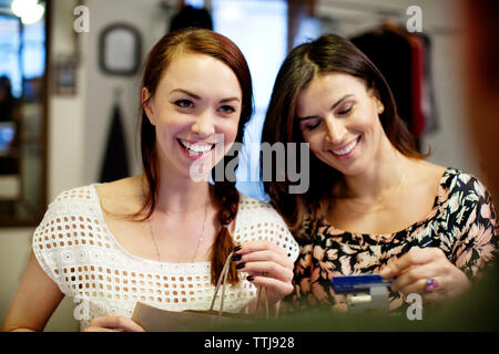 Happy owners with credit card and shopping in store Stock Photo