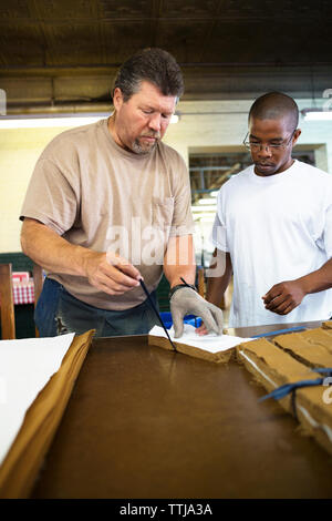 Man training coworker in factory Stock Photo