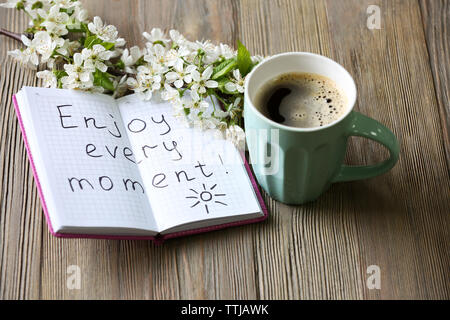 Cup of fresh coffee and note on wooden background Stock Photo