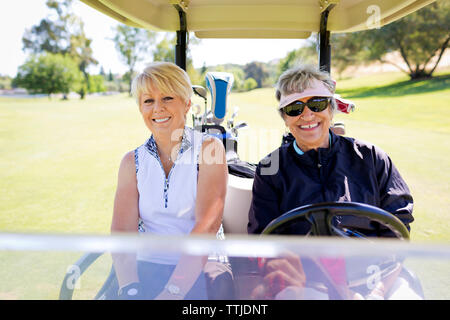 Portrait of women sitting in golf cart Stock Photo