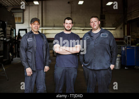 Mechanic fixing bus tire in workshop Stock Photo