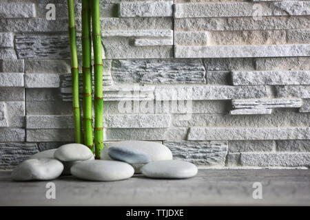 Composition of spa pebbles and bamboo on grey wall background Stock Photo