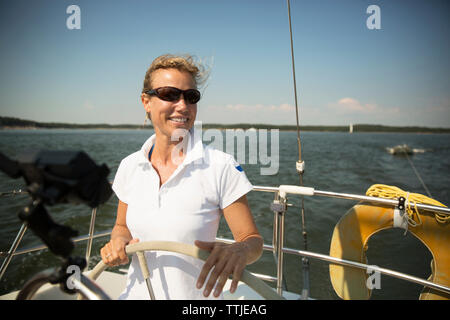 Portrait of man standing while traveling in yacht Stock Photo