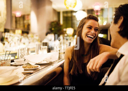 Happy couple talking while sitting in restaurant Stock Photo