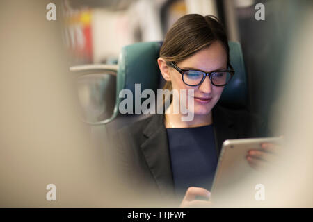 Happy businesswoman using tablet while traveling in subway train Stock Photo