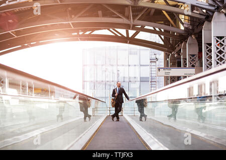 Man standing on escalator at subway station Stock Photo