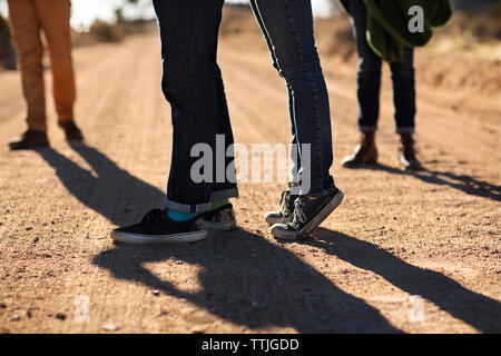 Low section of friends standing on field Stock Photo