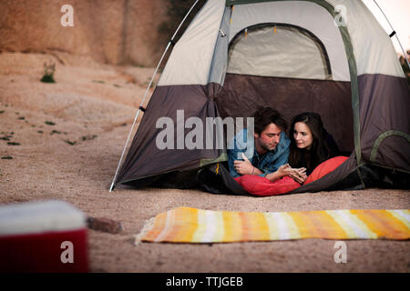Couple talking while lying in tent Stock Photo