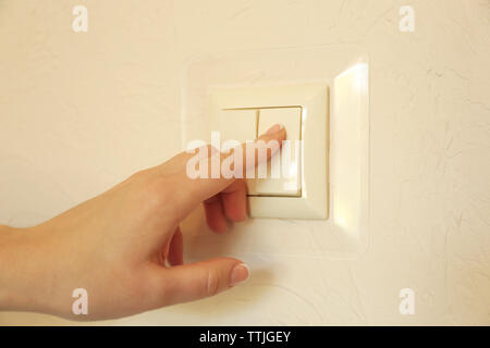 A finger is turning on a light switch Stock Photo